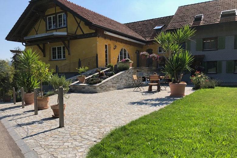 SAKRET Schweiz Referenzen | Natursteinboden vor Haus Frontalansicht